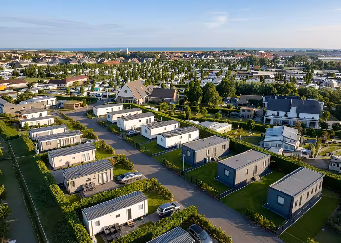 Nieuwe stacaravan op een groene staanplaats aan de Belgische kust