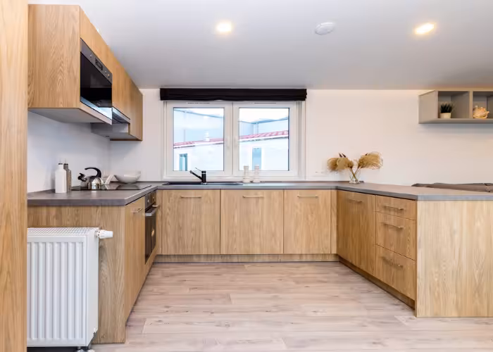 Keuken van de Lark Murano met houten kasten en raam boven de spoelbak