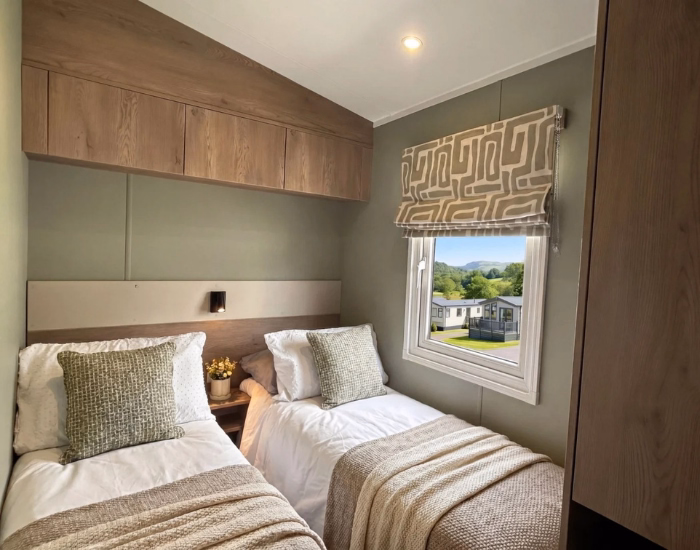 Slaapkamer van de Victory Verve met twee eenpersoonsbedden en bovenkasten