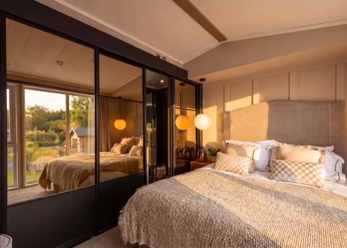Slaapkamer van de Victory Lakewood met tweepersoonsbed en spiegelkasten
