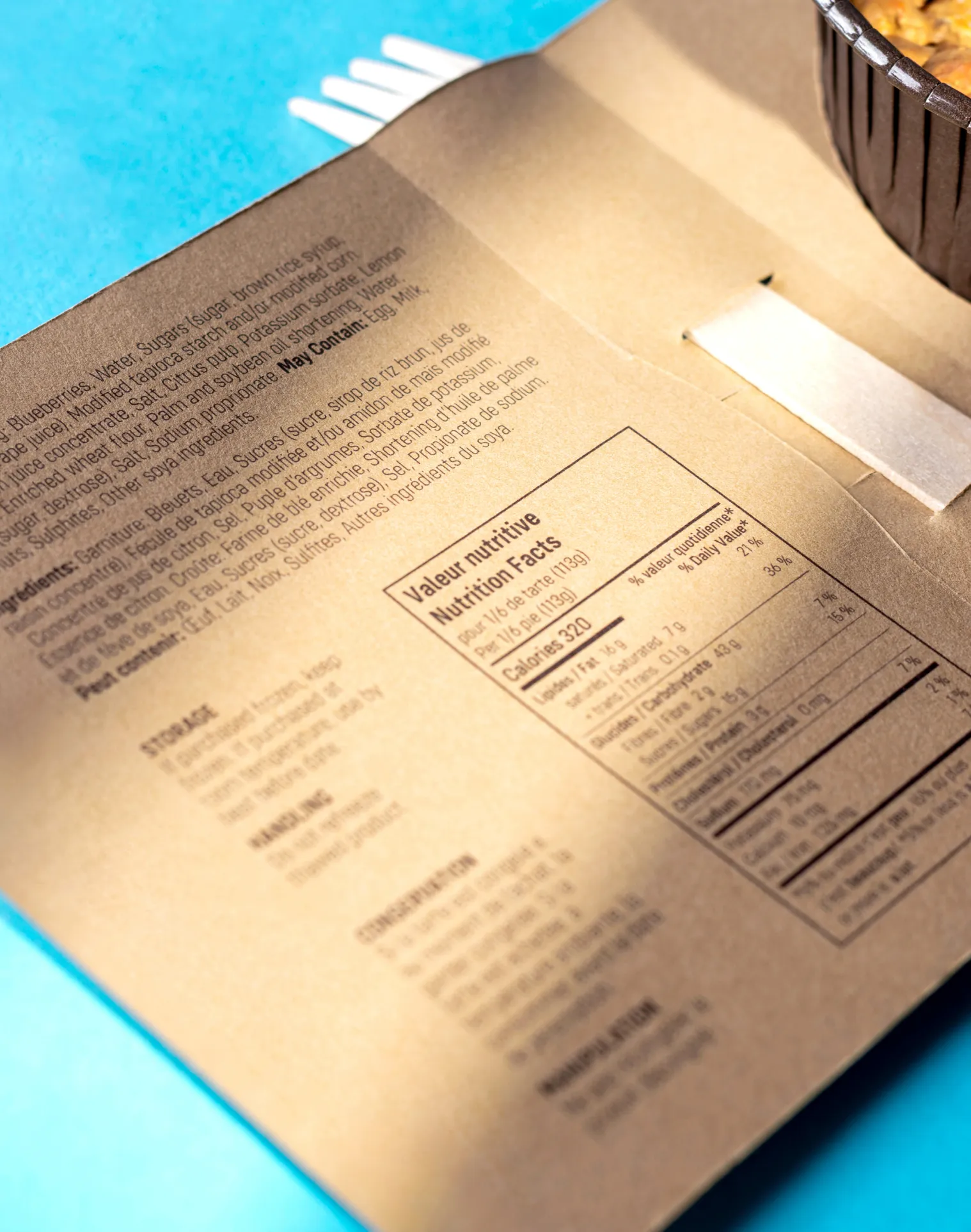 close up of inside flap of pie packaging to show text detail on a blue background with a fake pie prop

photographed by Kayleigh Lord