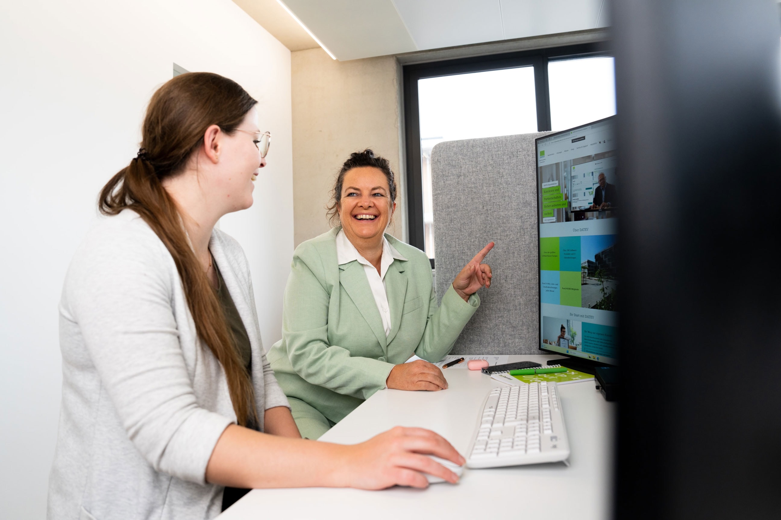 Zwei Steuerberaterinnen arbeiten gemeinsam am digitalen Arbeitsplatz – flexible Steuerberatung und Online-Prozesse 2025.
