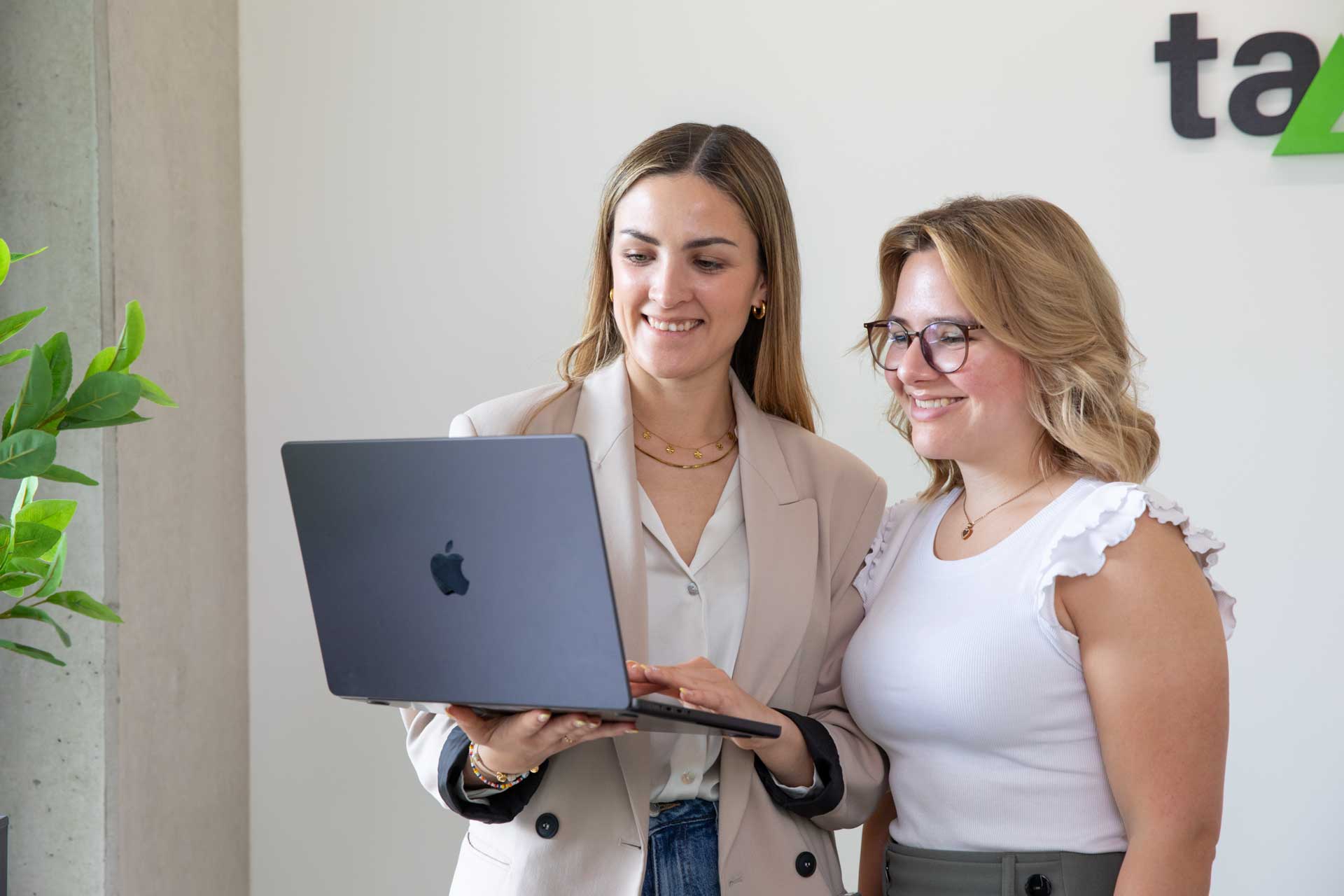 Digitale Buchführung in der Cloud: Team arbeitet gemeinsam am Laptop an Finanzunterlagen.