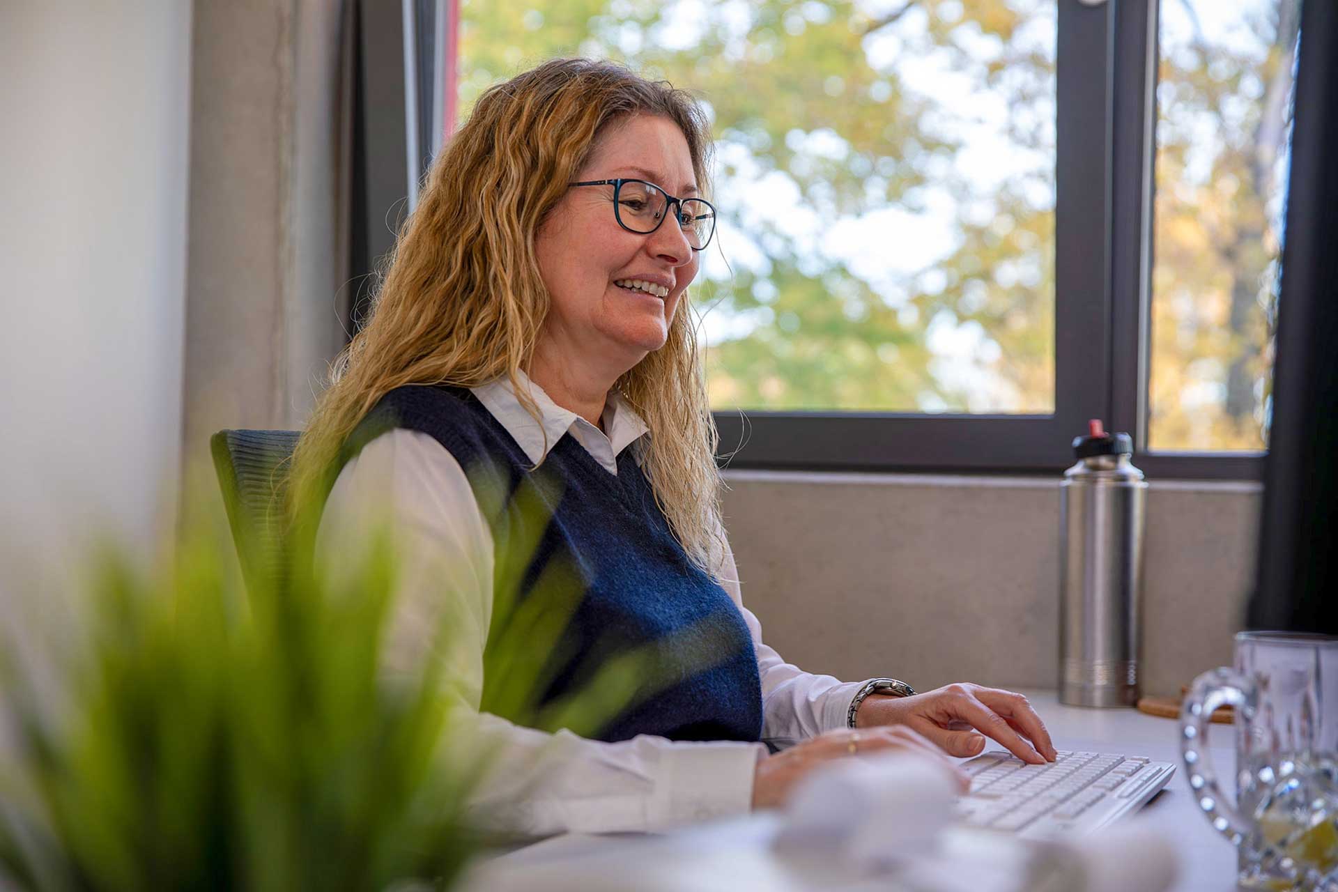 Mitarbeiterin arbeitet am PC an der Lohn- und Gehaltsabrechnung im Büro.