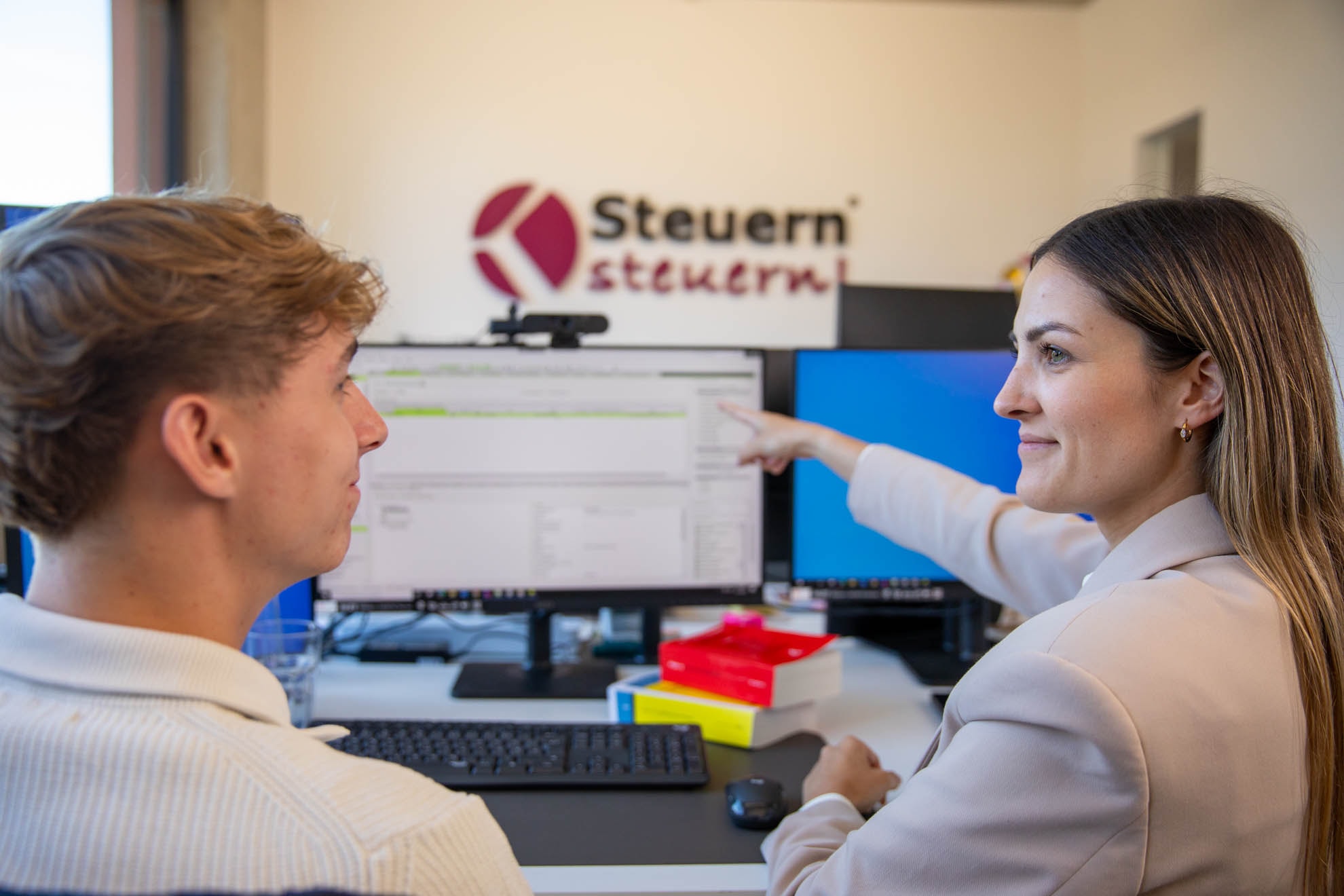 Steuerberaterin erklärt Lohnbuchhaltungsdaten am Bildschirm, Fokus auf korrekte Abrechnung.