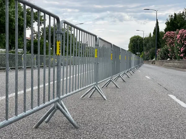 Barrières de sécurité alignées en extérieur pour encadrer un espace public ou un chantier.