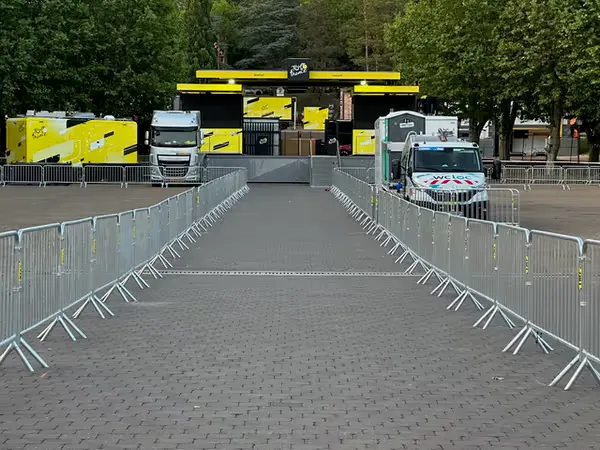 Barrières Vauban installées le long d’une route lors d’un événement sportif type Tour de France pour sécuriser le public.