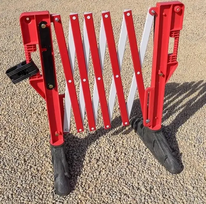 Barrière extensible en plastique repliée, compacte pour le transport et le stockage.