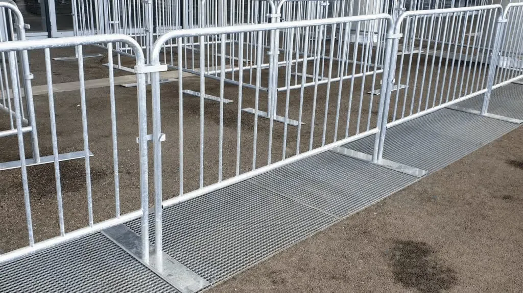 Barrières de chantier avec pieds plats en platine, installées pour sécuriser une zone temporaire.