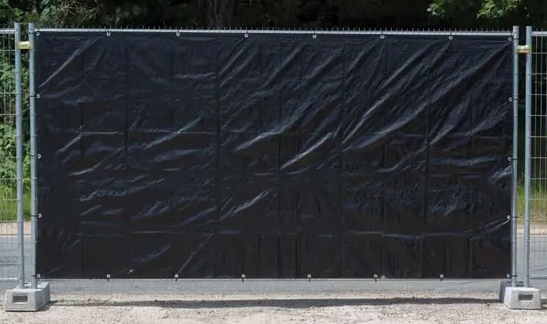 Clôture de chantier avec bâche noire utilisée pour sécuriser et délimiter une zone.