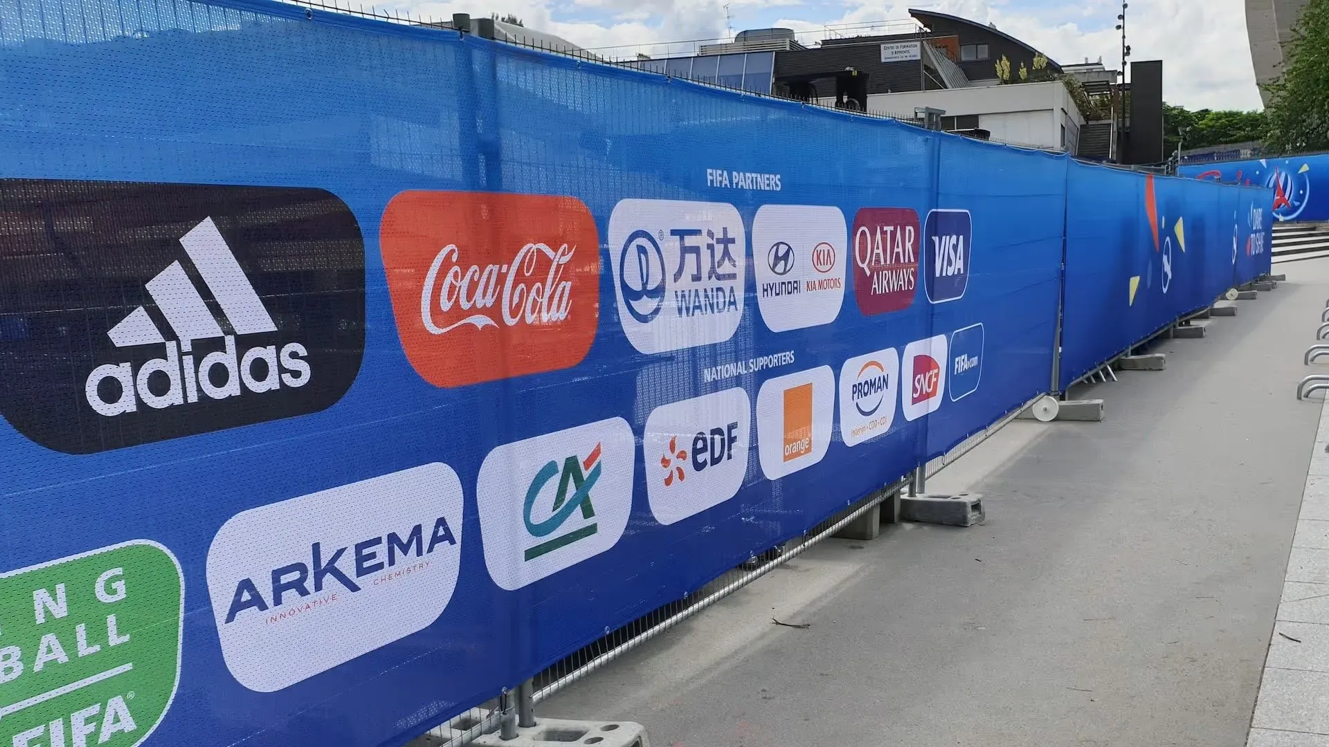 Bâche publicitaire fixée sur une clôture pour valoriser une marque ou un message.