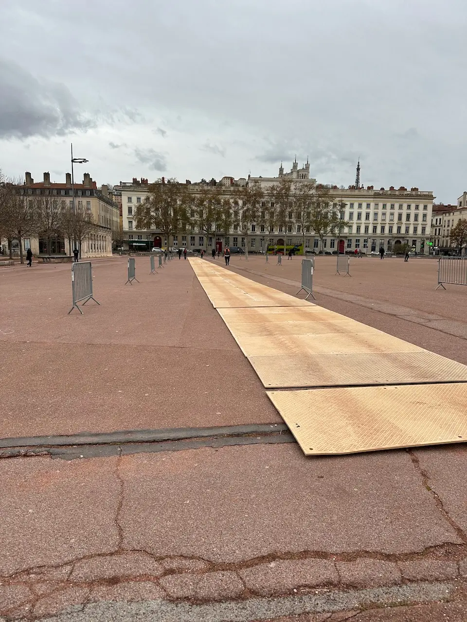 Cheminement en plaques de roulage pour accès piéton sur place urbaine, protection du sol et sécurisation des déplacements.