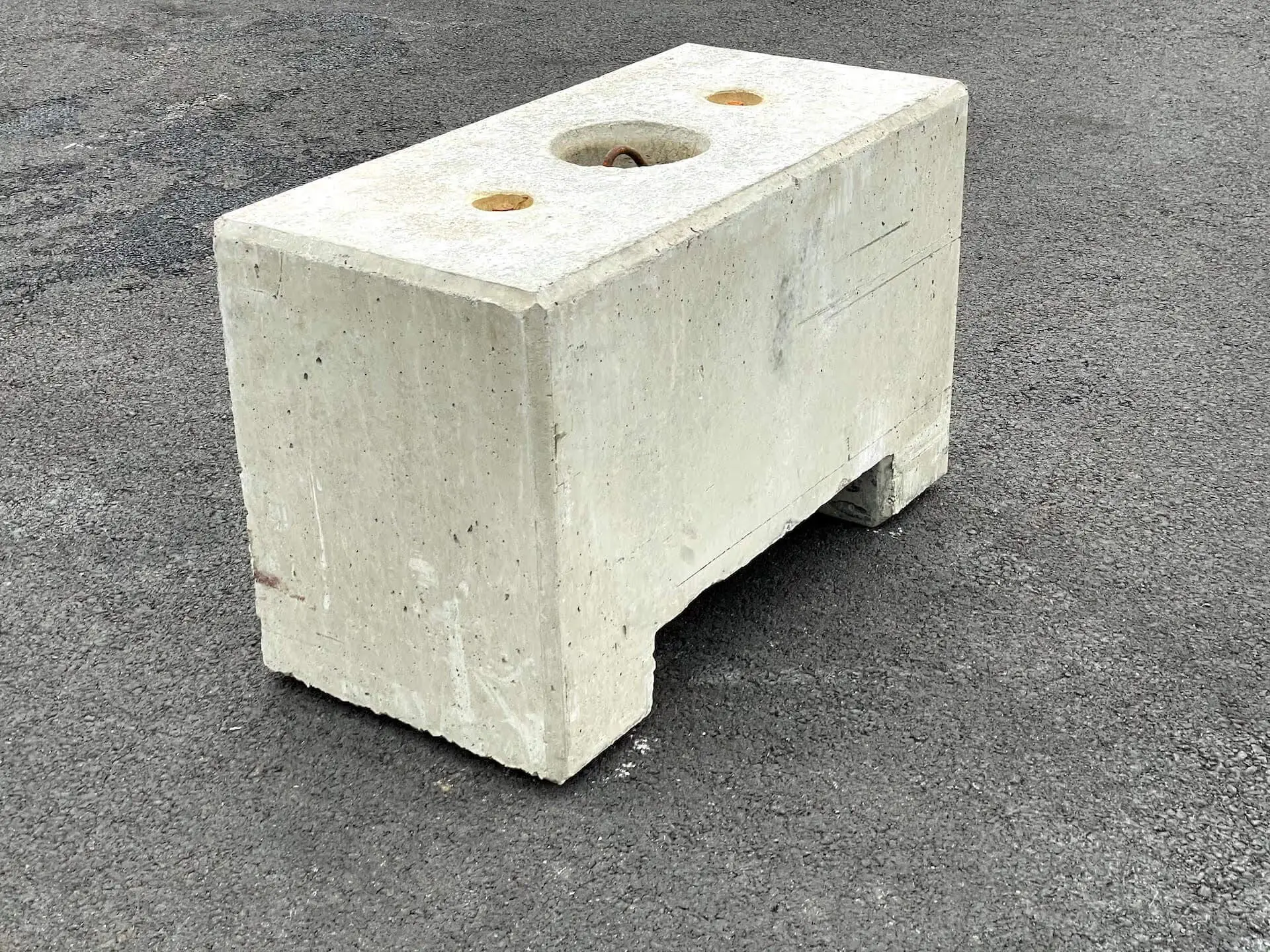 Bloc en béton massif de 600 kg avec réservations pour levage et manutention.