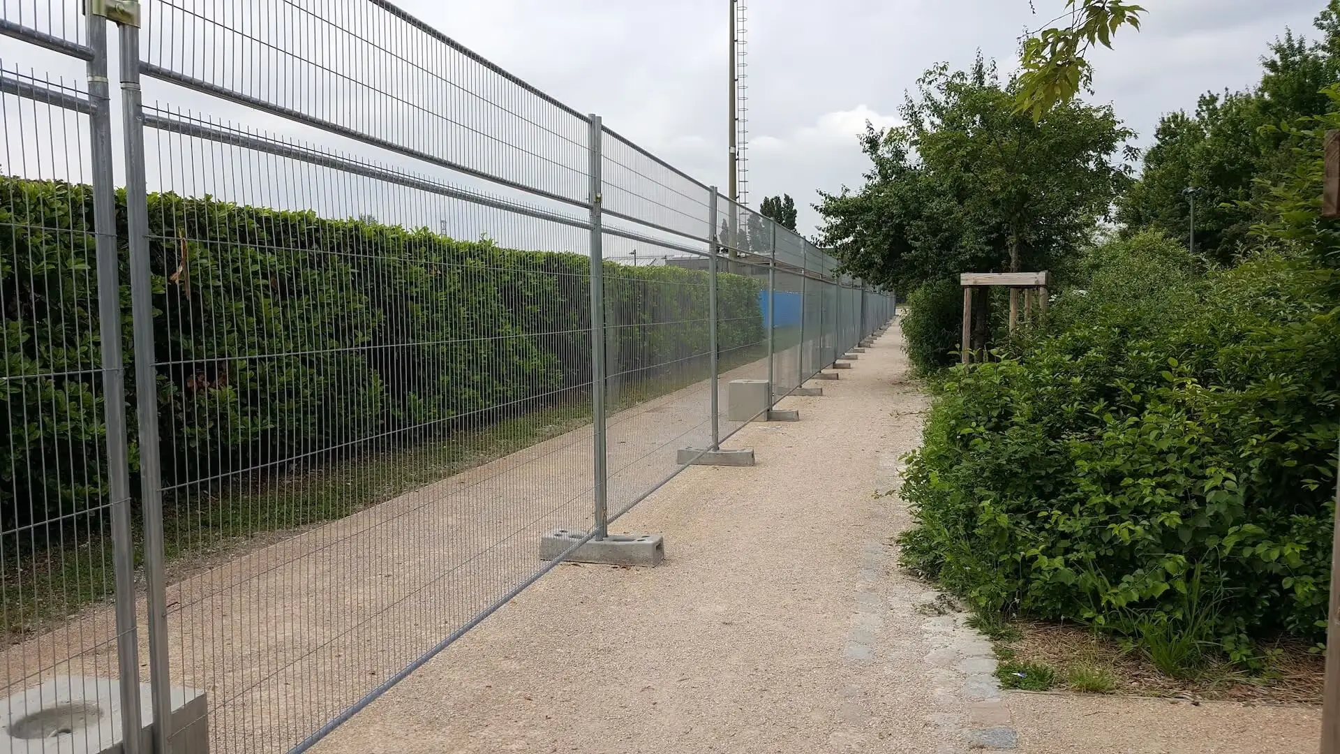 Clôture de chantier longue distance installée le long d’un chemin pour sécurisation et balisage de zone