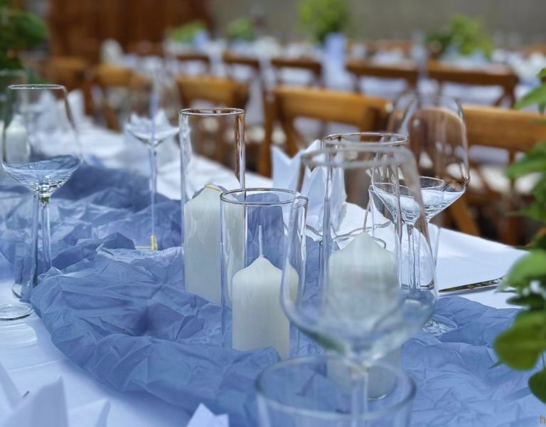 Gedeckter Hochzeitstisch mit Weingläsern und Kerzen als Tischdekoration bei einer Hochzeitsfeier.