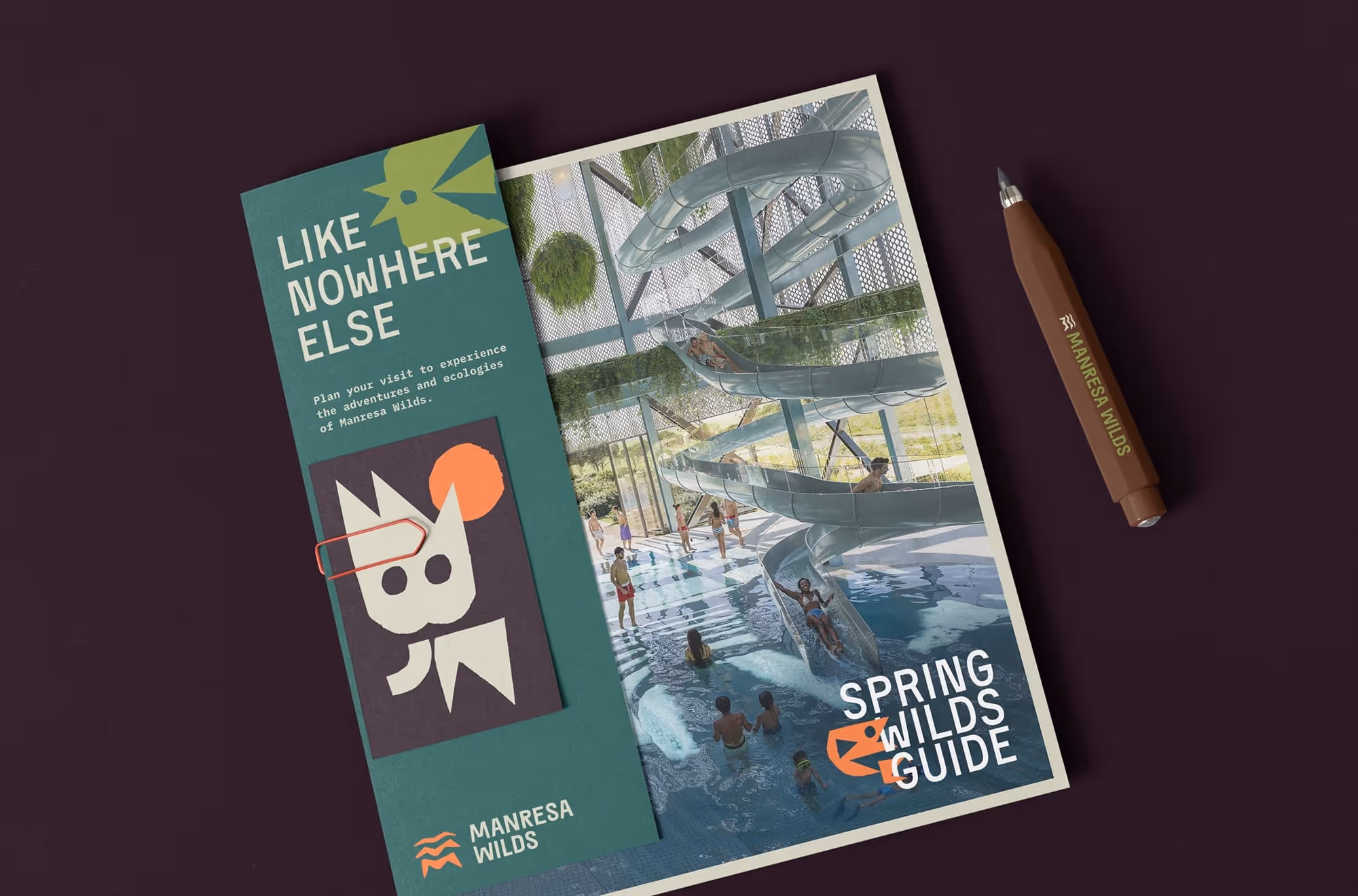 Brochure titled 'Spring Wilds Guide' showing an indoor water slide with people and a green panel reading 'Like Nowhere Else' with Manresa Wilds branding.