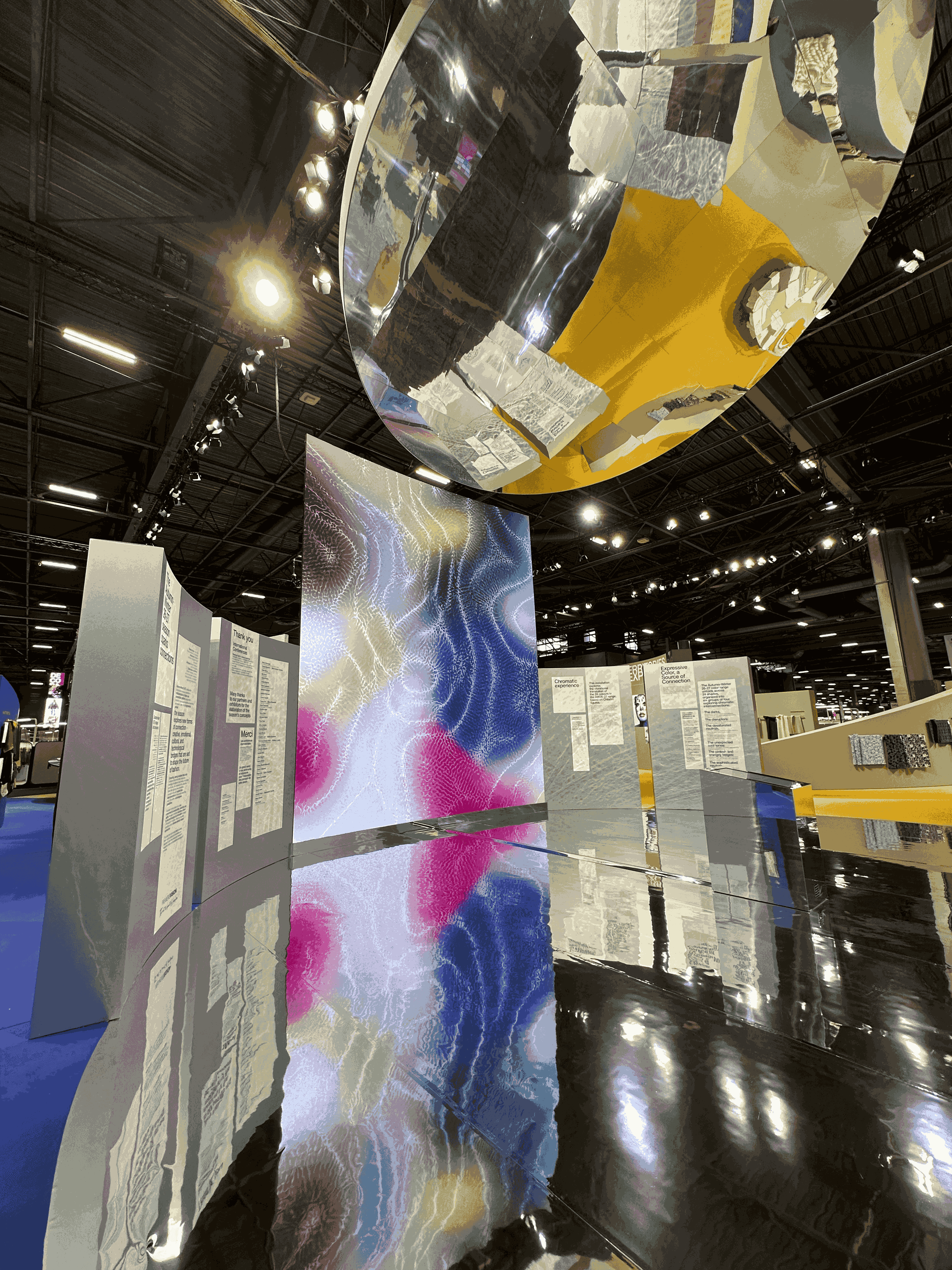 Lumen Resonance à Première Vision : panneaux imprimés suspendus sous une sphère miroir