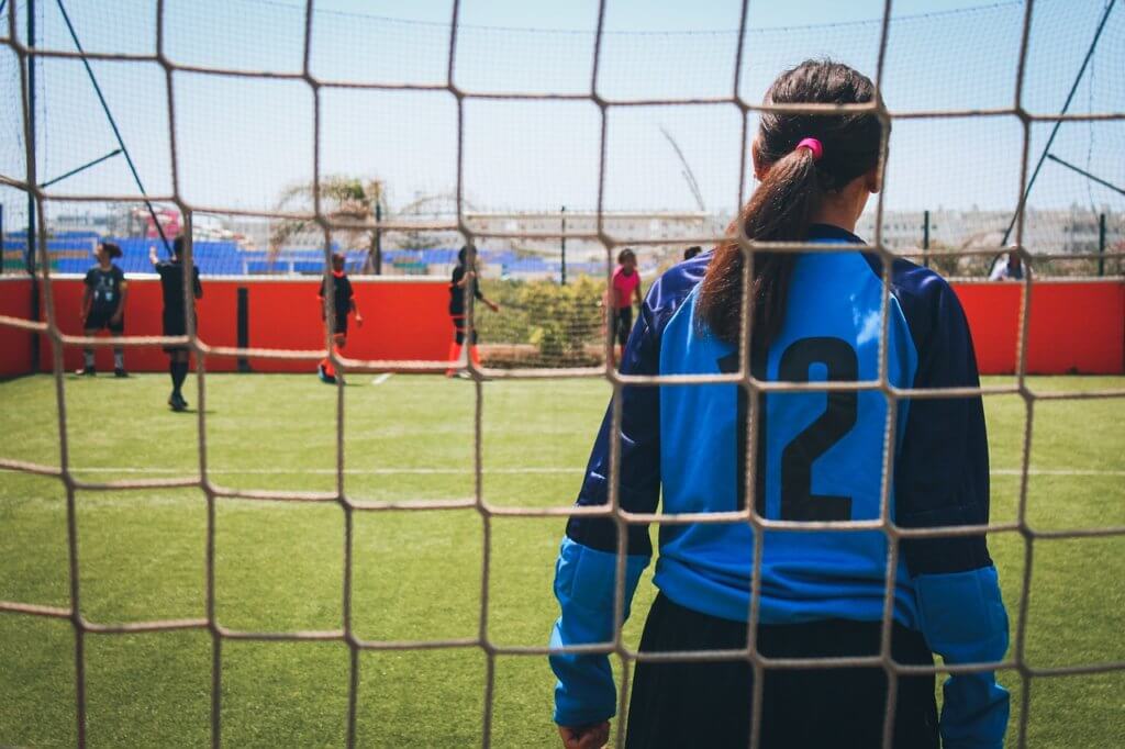 Motivated female athlete staying focused while playing goal.