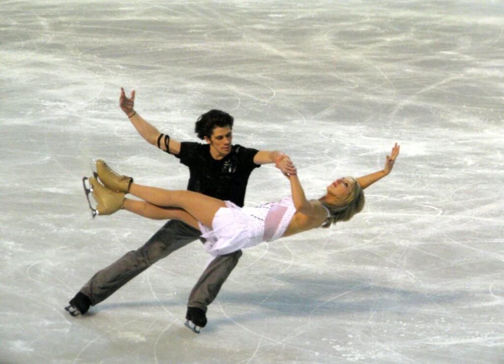 Pairs figure skating, man and woman executing beautiful glide. 