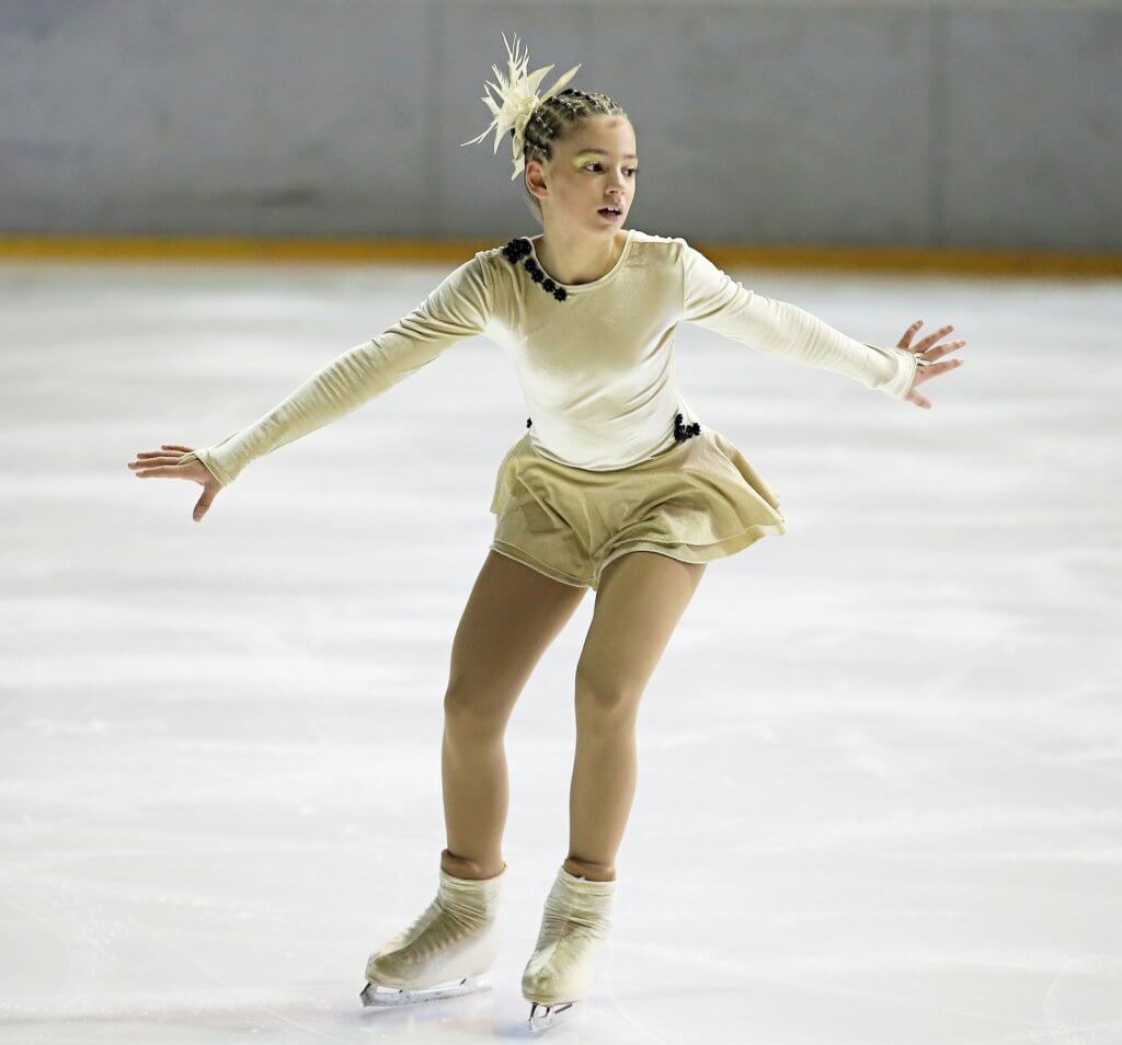Girl participating in sport, figure skating on ice