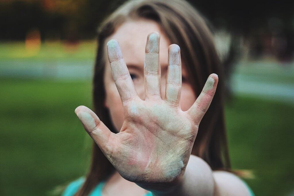 Creative kid with colour on her hand showing creativity