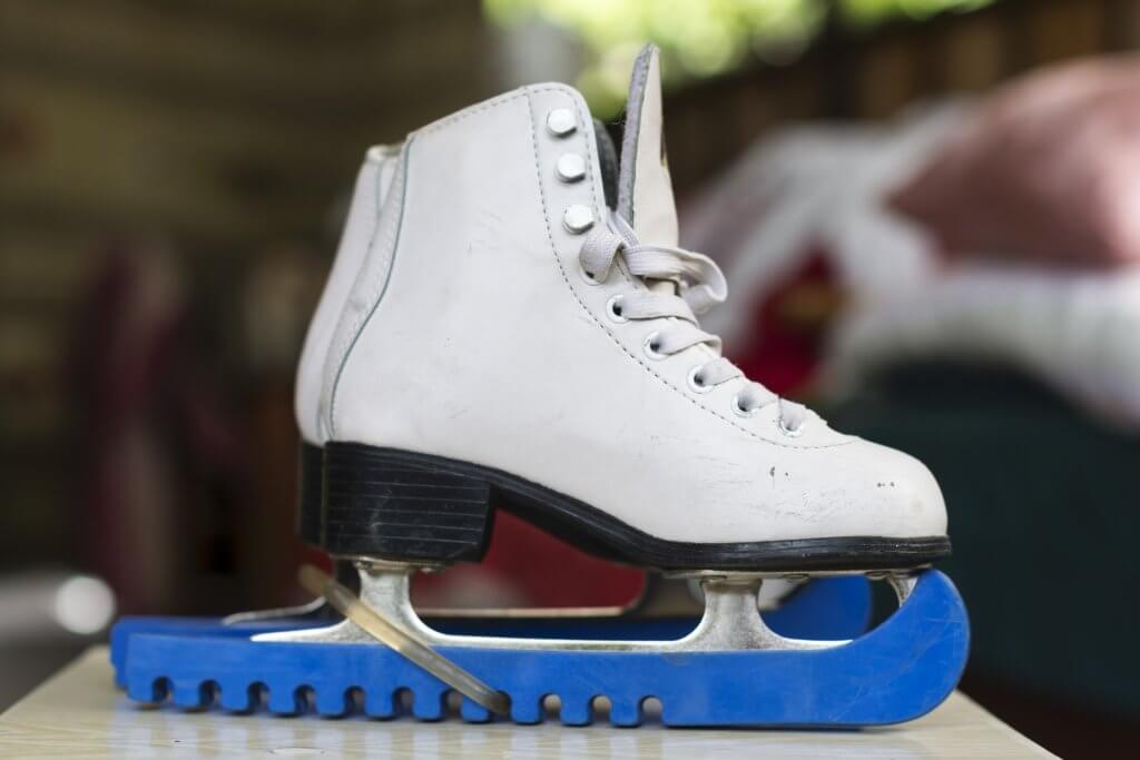 Figure skates on the sidelines because overdue class fees prevented participation.