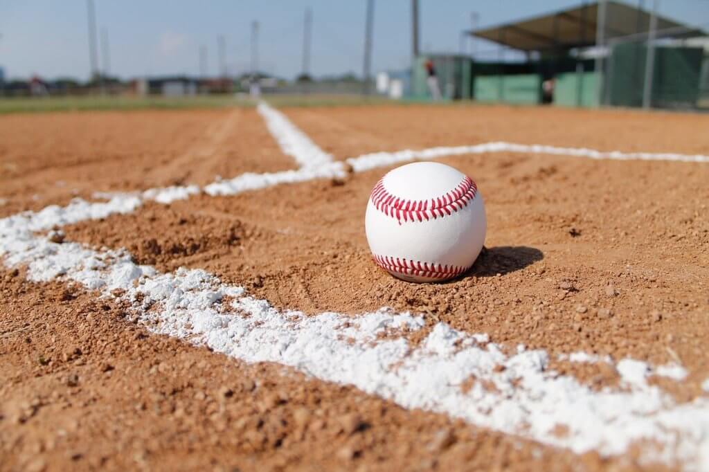 Baseball sitting on the dirt in a baseball diamond