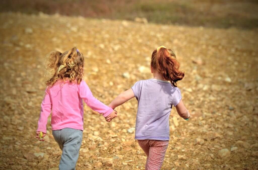 Two girls holding hands in friendship 