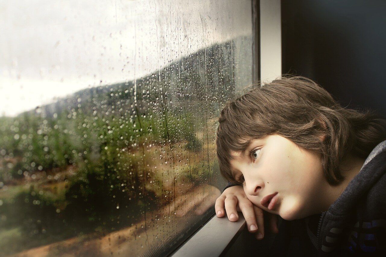 Tired child looks out the window