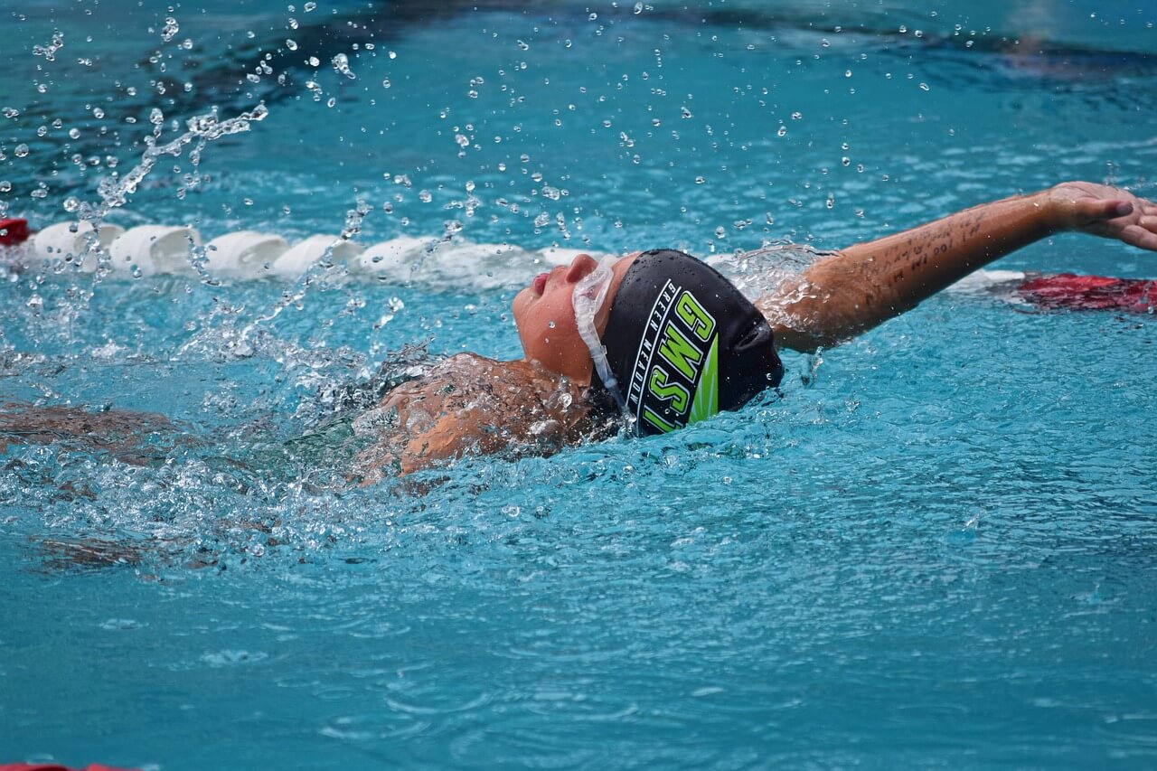 Swimmer performing backstroke representing success quotes about swimming