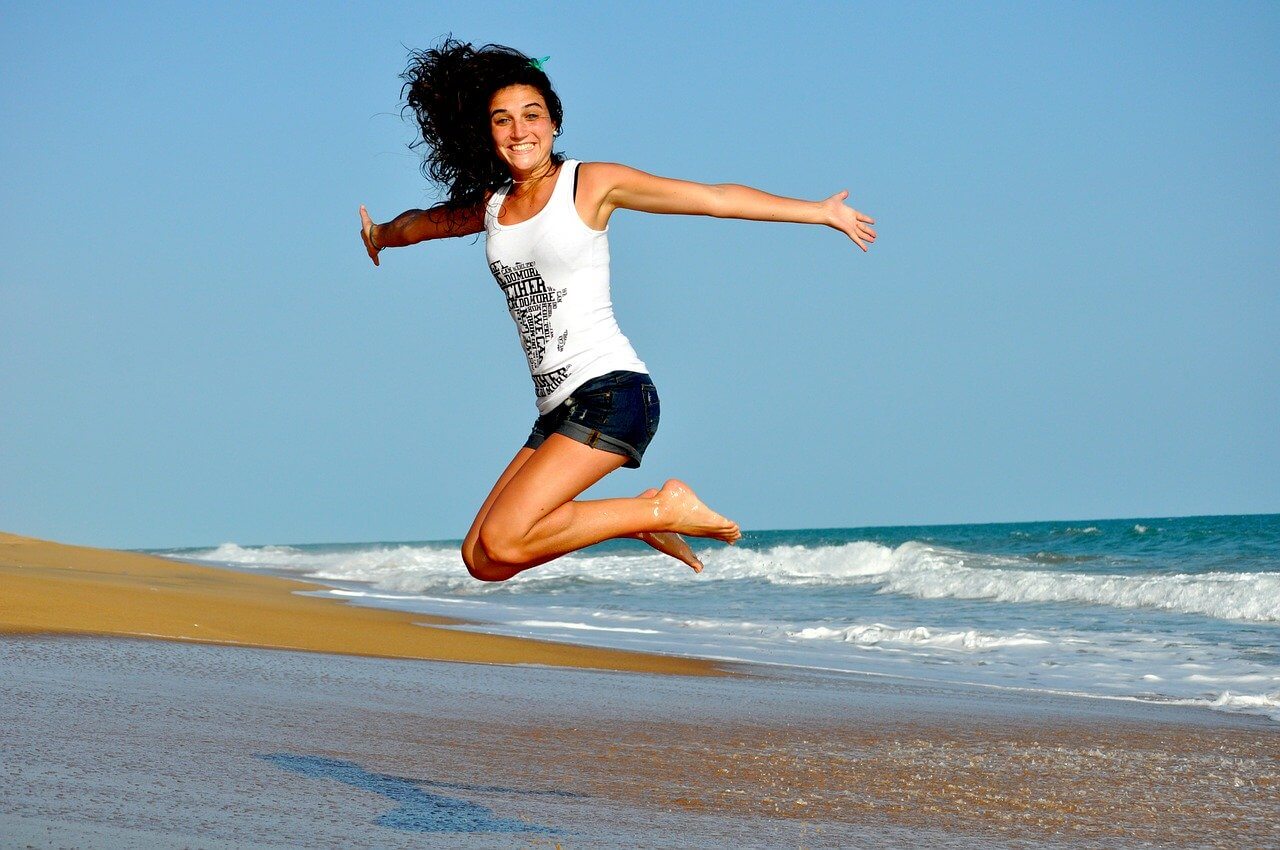 Woman jumping on the beach and having fun