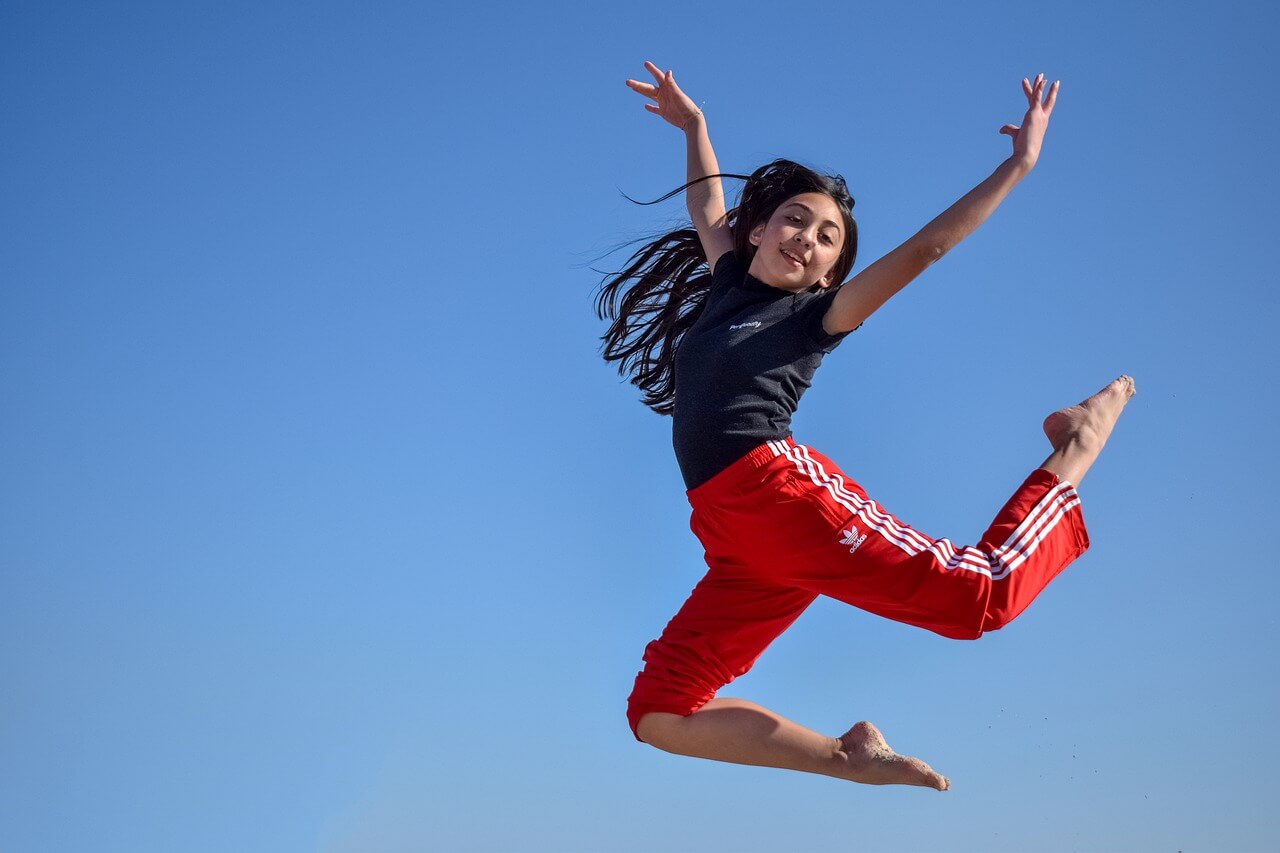 Girl jumping in the air at summer gymnastics camp