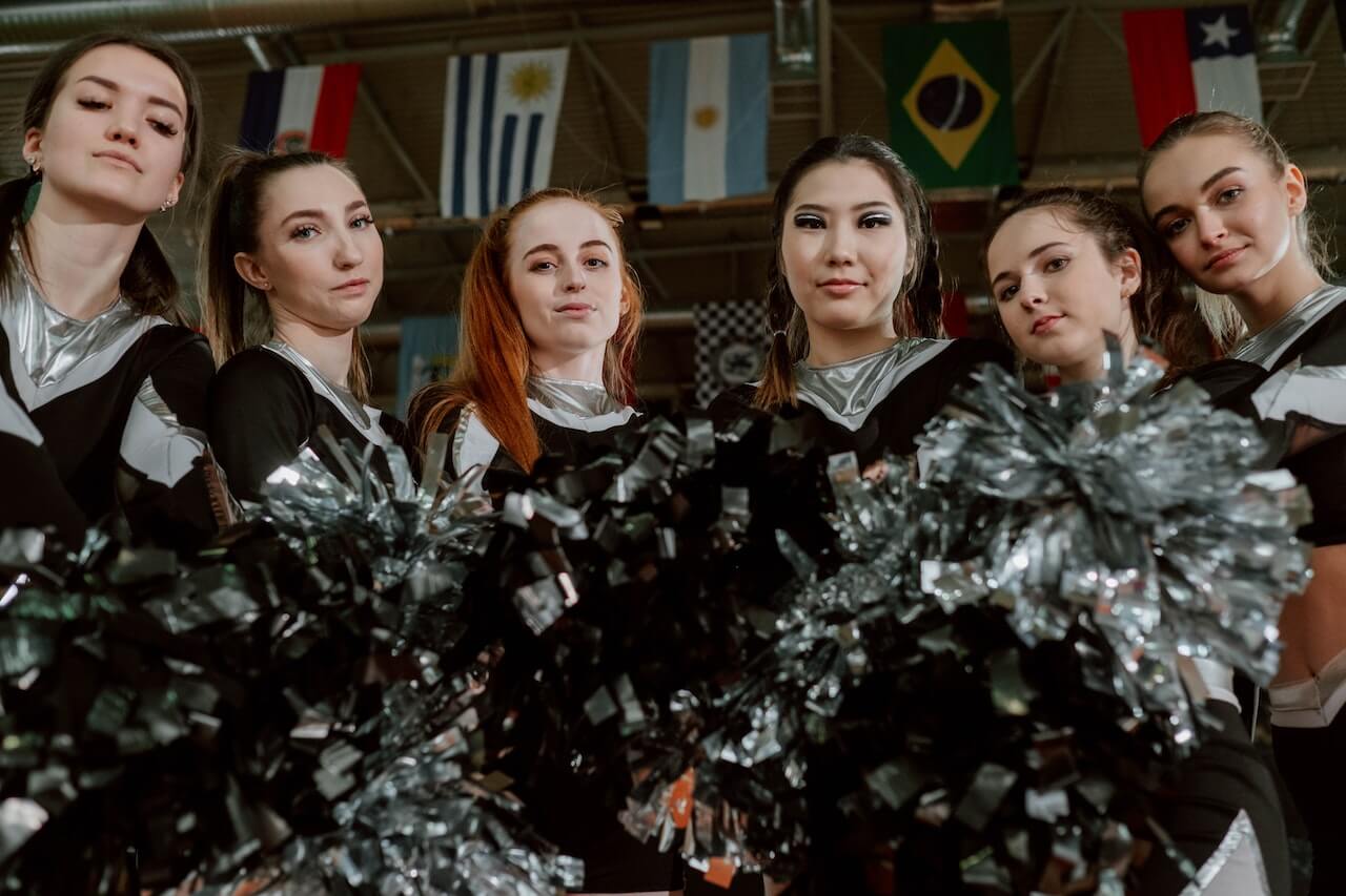 Cheerleaders holding pom-poms and looking strong. 