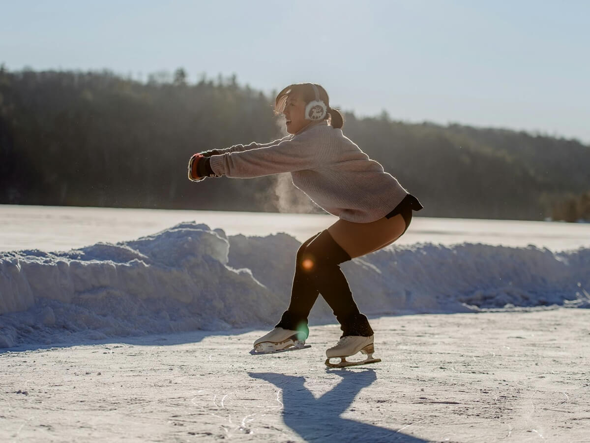 Woman figure skating on outdoor rink.
