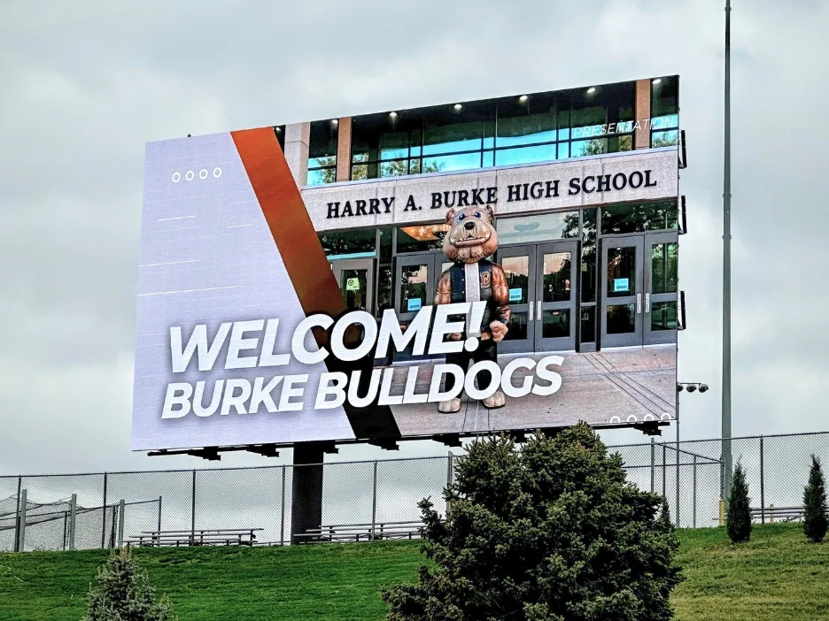 Billboard welcoming Burke Bulldogs at Harry A. Burke High School with a mascot. 