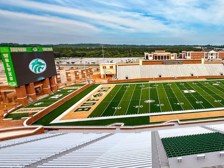 A large video board displaying a wolf logo in a sports stadium named Buford Wolves.