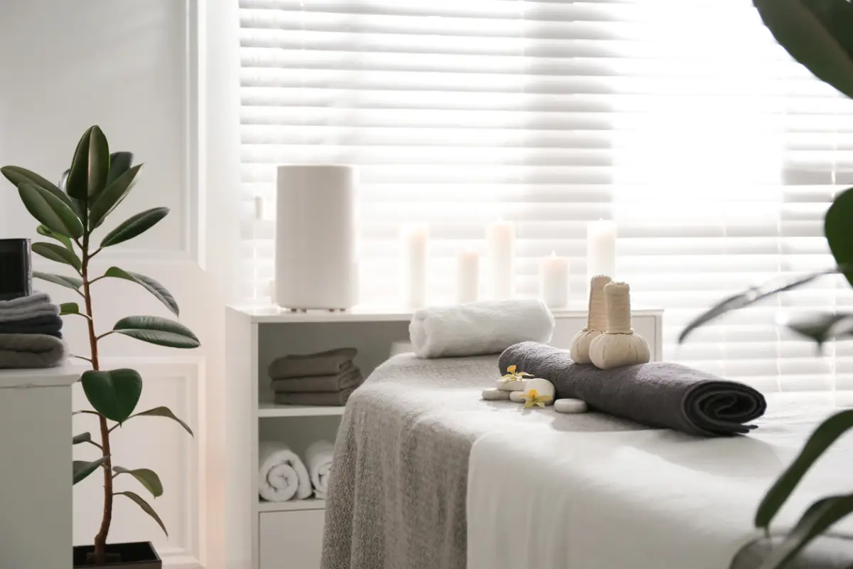 Herbal bags, towel and stones on couch in spa salon
