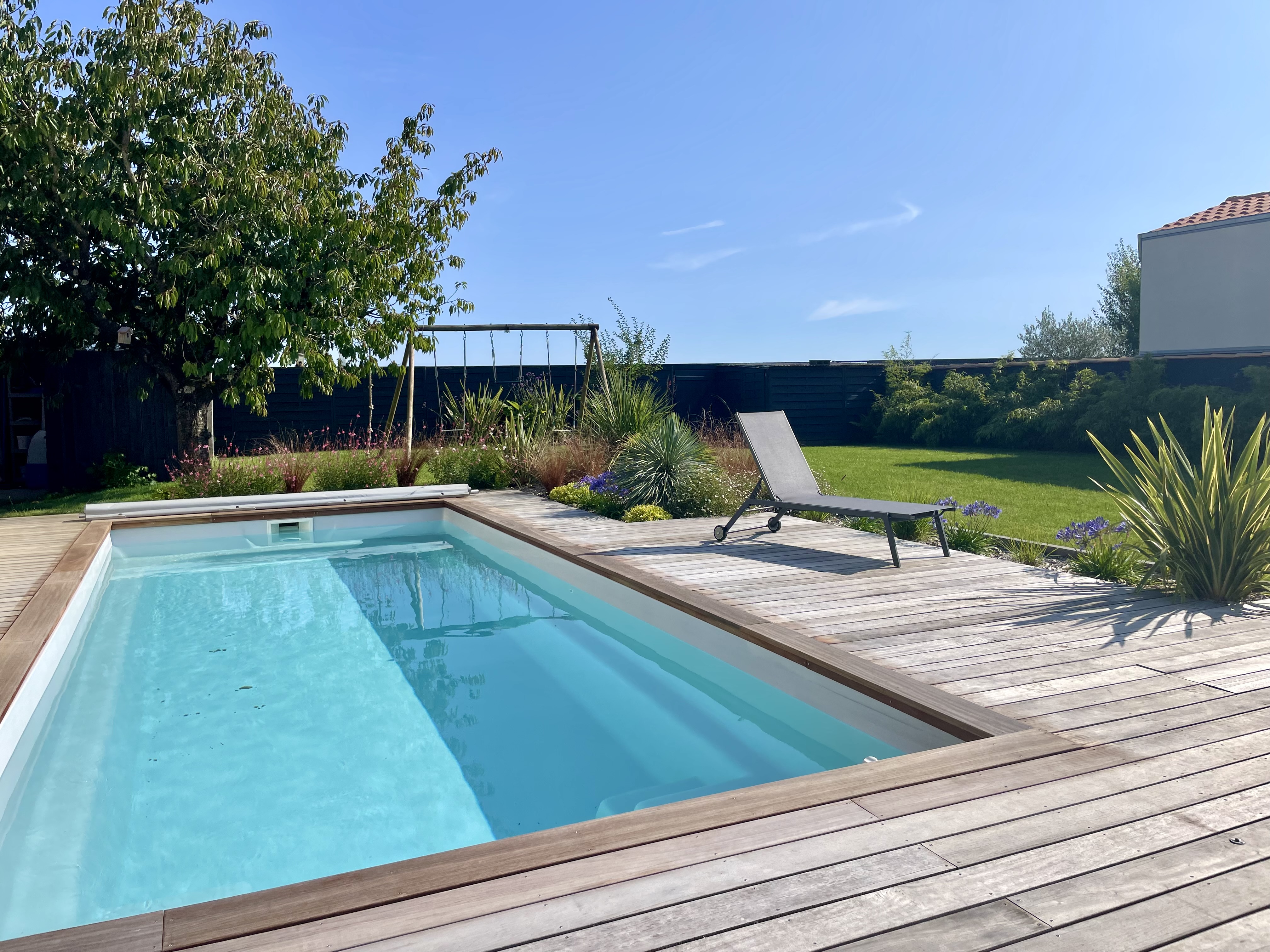 Arrosage automatique d’un jardin paysager avec pelouse, massif végétal et terrasse en bois