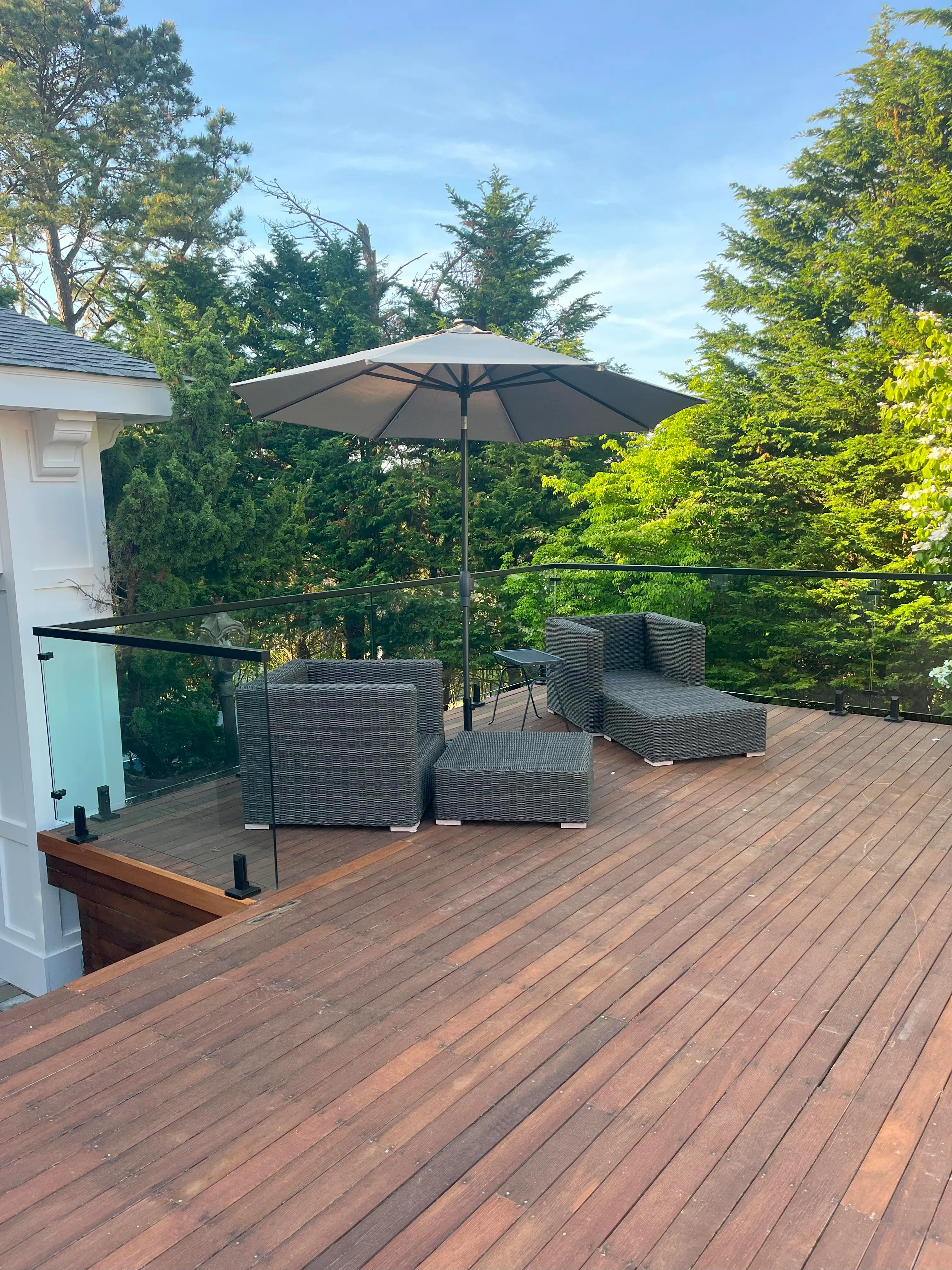 Custom Deck Job With Hardwood Deck Glass Railing and fun outdoor furnature