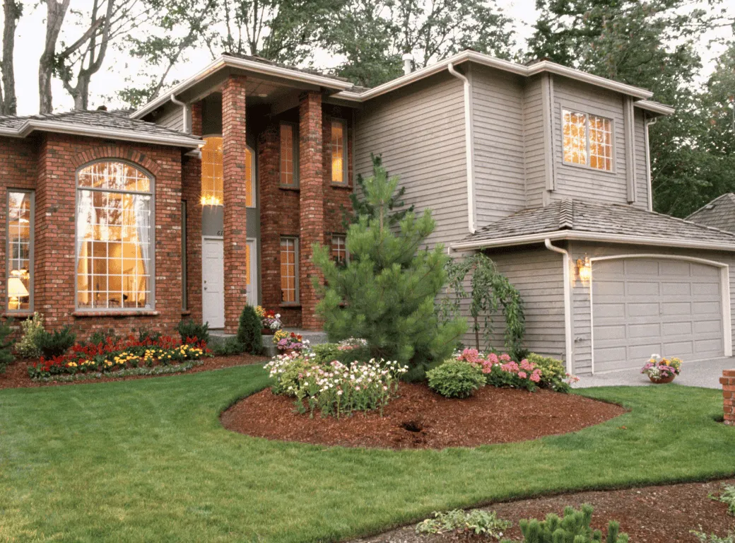 Elegant Suffolk County home with lush green lawn, colorful flower beds, and professional landscaping by Trent’s Maintenance.