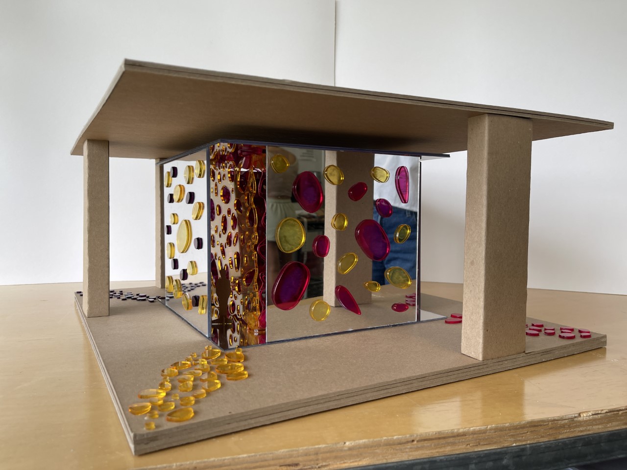 Scale model of an art installation using mirrors and colored glass.