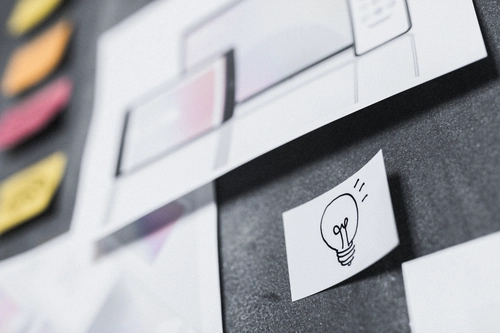 An ideation board of sticky notes with a lightbulb on one of them