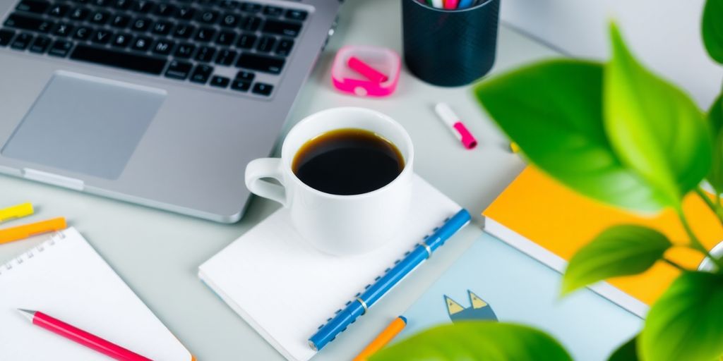 Vibrant workspace with laptop, coffee cup, and notepad.