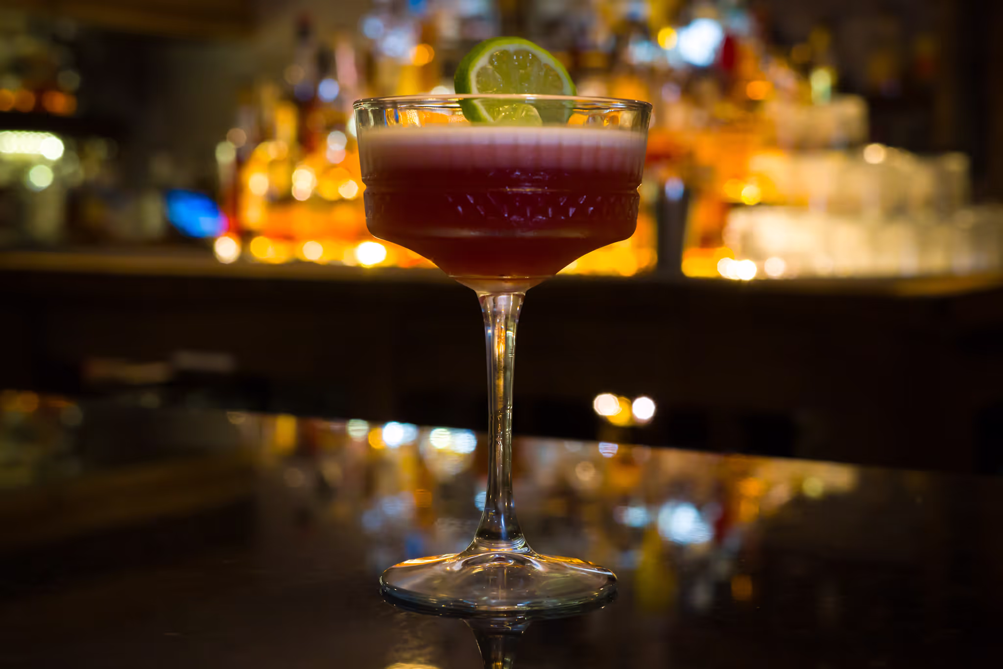 Picture of the blackberry margarita, with a slice of lime.