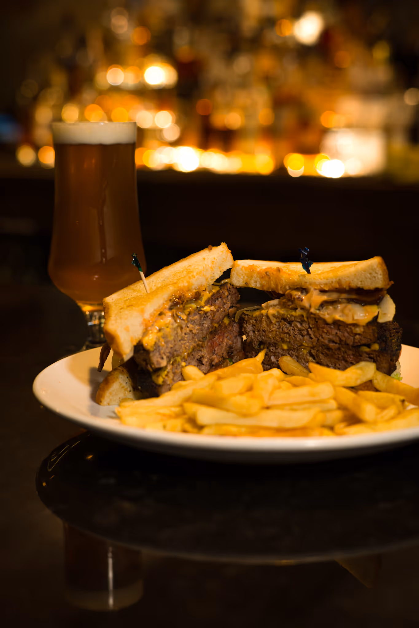 Picture of the dish Cricket Melt, which is Texas Toast, 2 Beef Patties, American cheese, lettuce, tomato, sautéed onions, bacon, special sauce and fries.