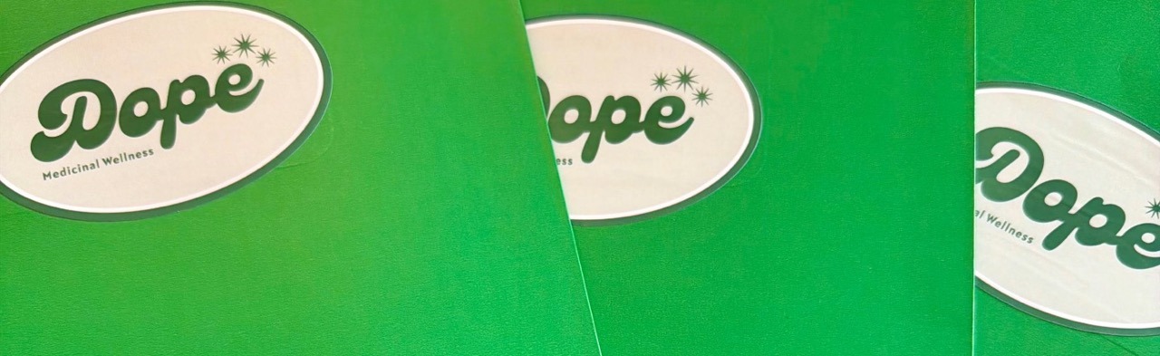 3 green Dope Medicinal Wellness patient resource folders at the Headwaters Provisions Patient Card Drive in Rogers, AR.