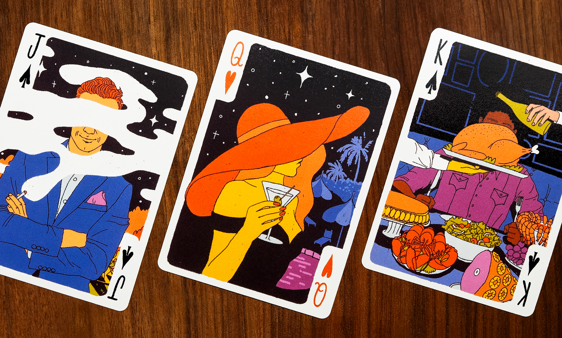 A jack, queen and king showing off the card’s illustrations including a woman holding a martini glass.