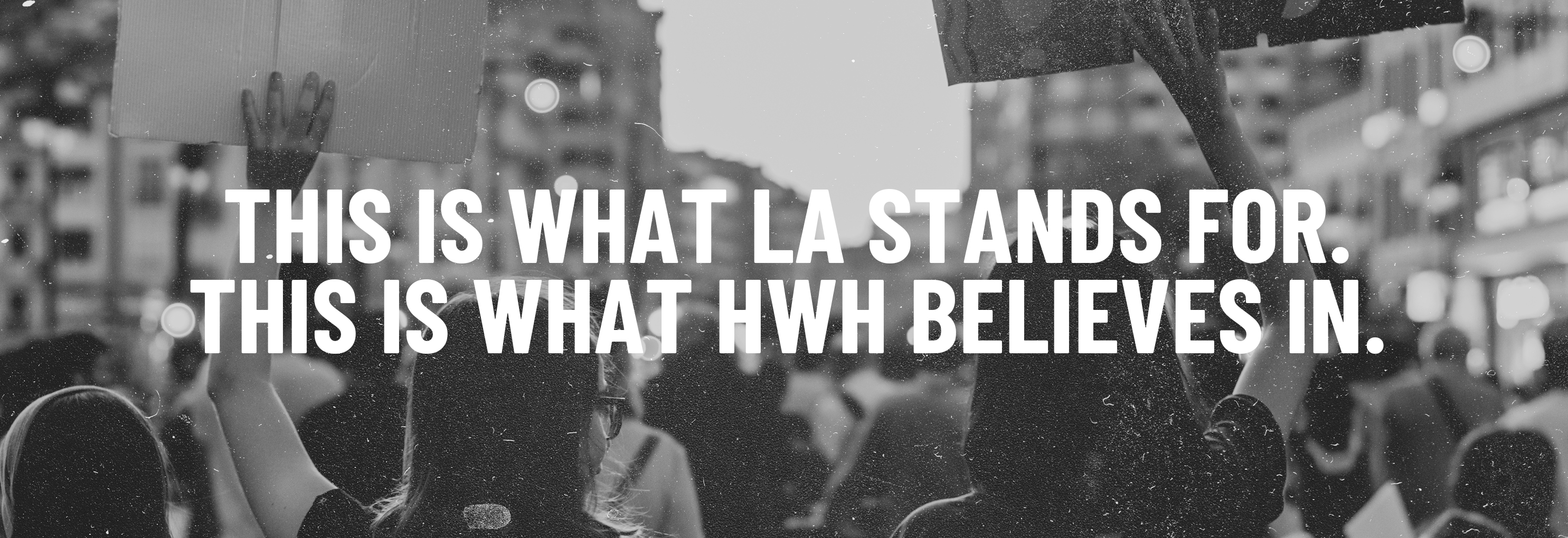 Black and white photo of protestors holding signs with text, “This is what LA stands for. This is what HWH believes in.”