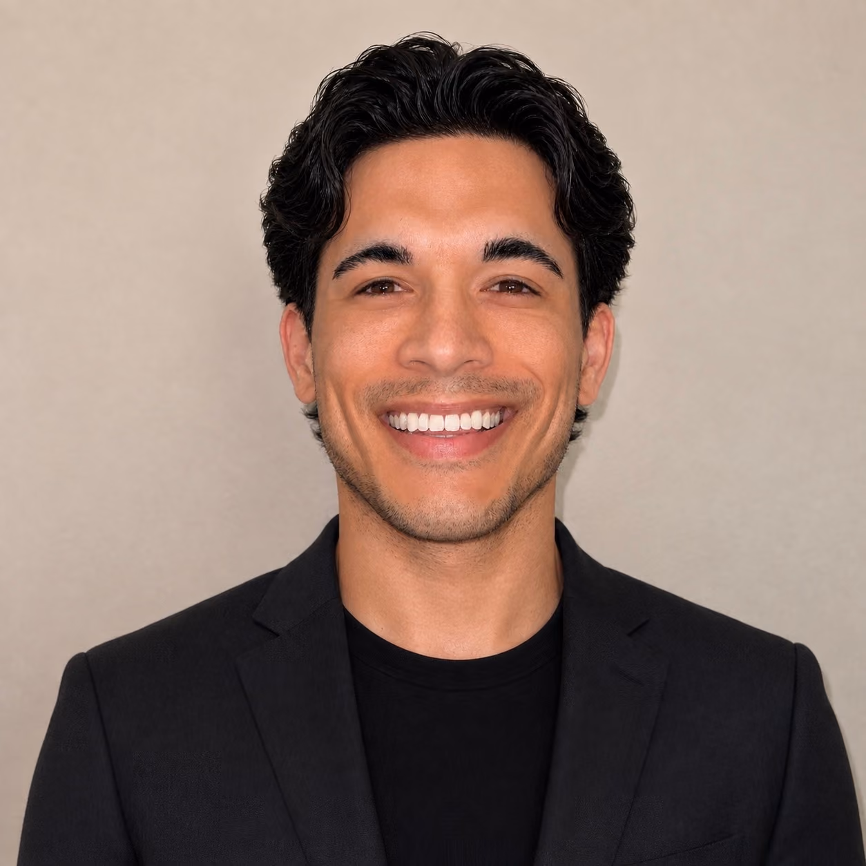 Male smiling with dark background wearing floral shirt