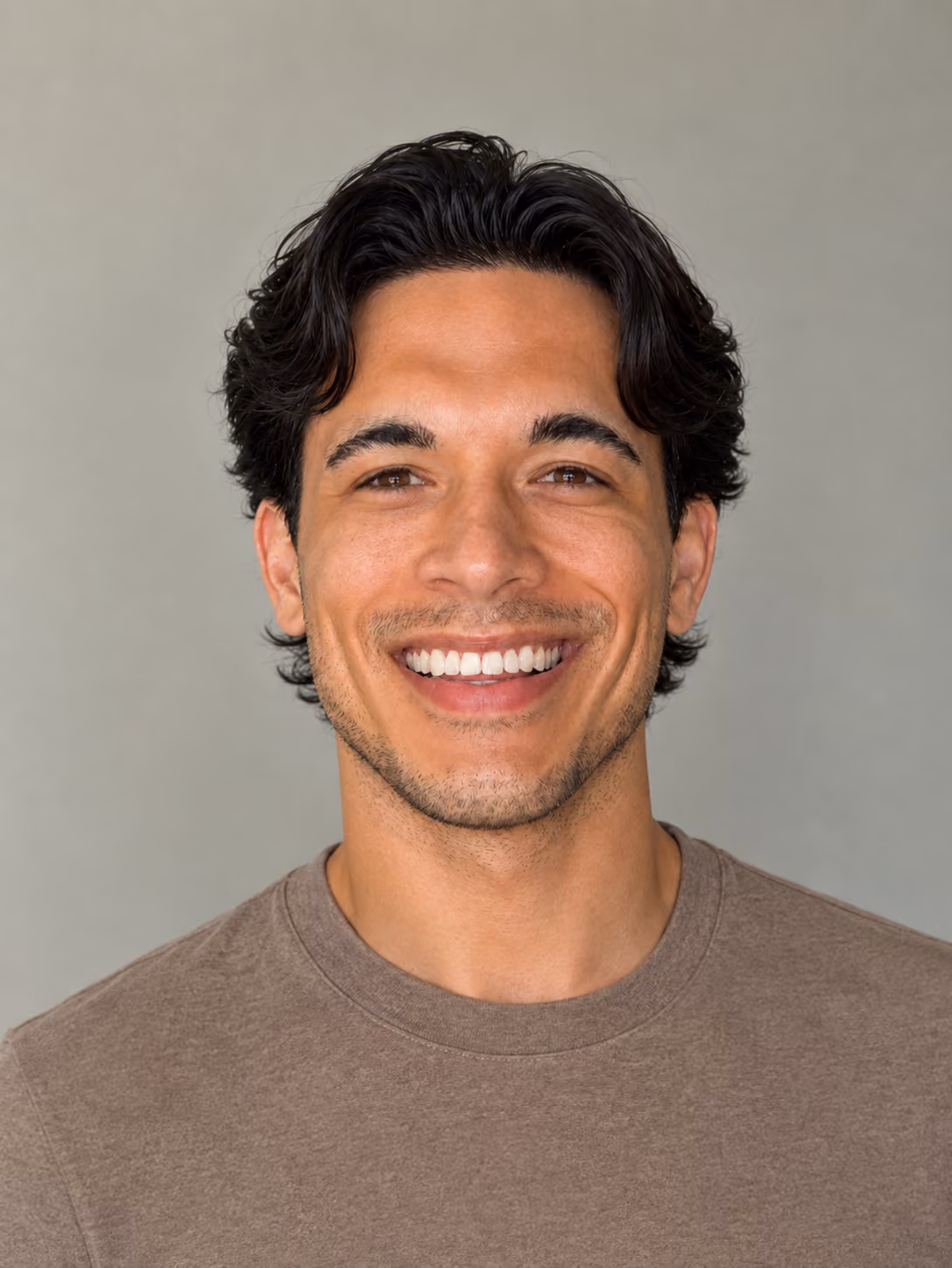 Male smiling with dark background wearing floral shirt